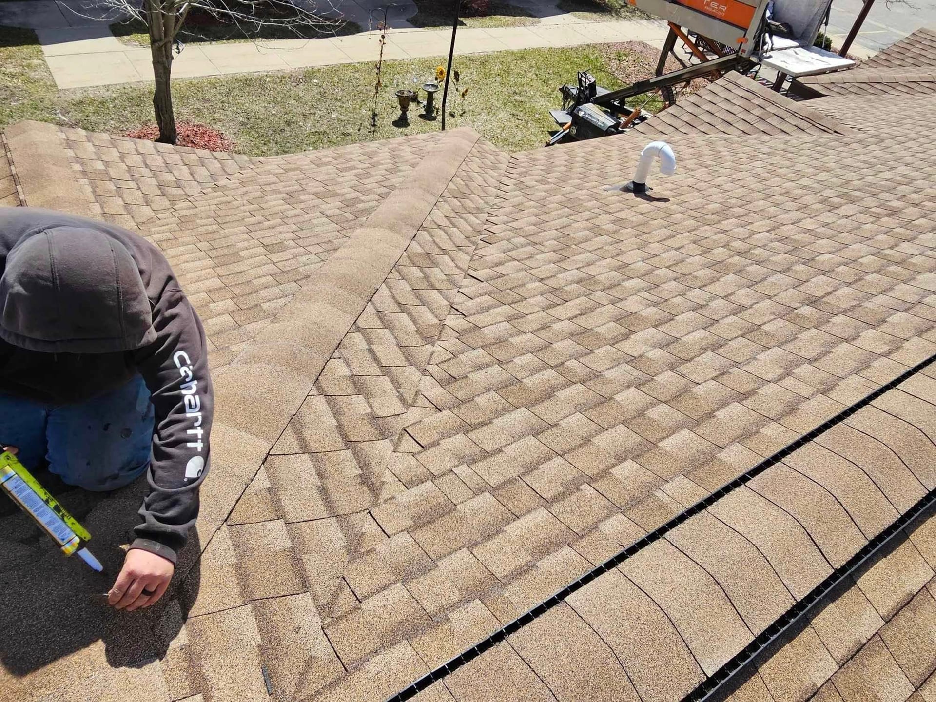RAO Roofing crew member sealing shingles during a storm damage roof repair on a Grant, MI home